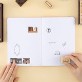  Hand holding opened book stamp and stamping on bullet journal