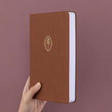 Tsuki ‘Vintage Rose’ Limited Edition Bullet Journal held in hand at spine angle in mauve background