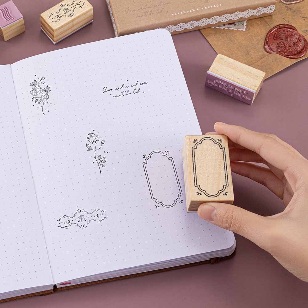 Tsuki ‘Vintage Rose’ Bullet Journal Stamp Set with vintage aesthetic on open Tsuki ‘Vintage Rose’ Limited Edition Bullet Journal with kraft paper letter on mauve background