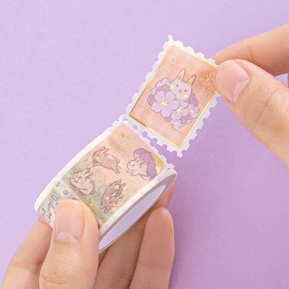 Stamp tape from Tsuki Bunny Blush Washi Tape Set designed with Blossom Bujo held in hands in lilac background