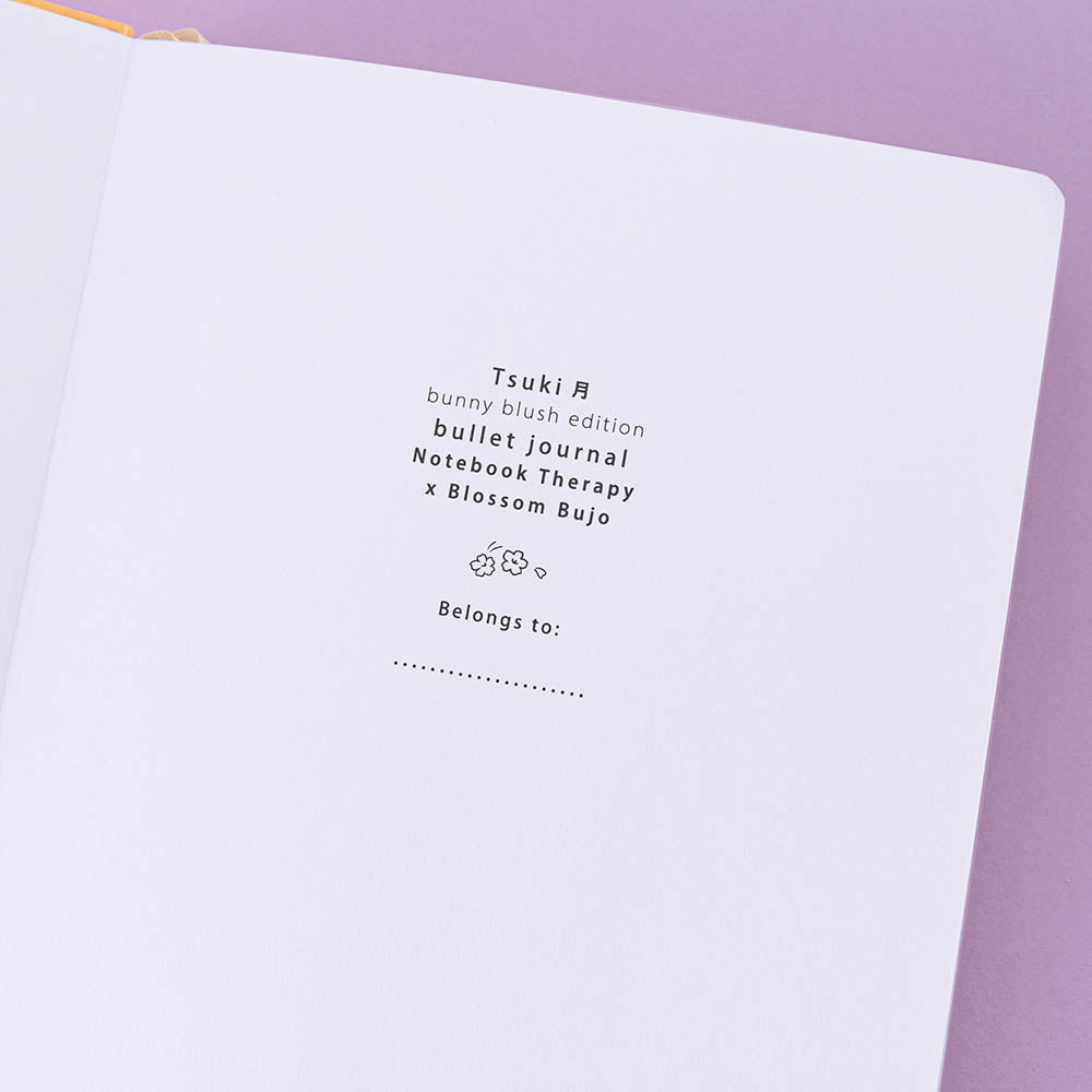 Close up of open front page of Tsuki ‘Bunny Blush’ Limited Edition Bullet Journal designed with Blossom Bujo on lilac background