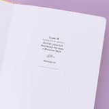 Close up of open front page of Tsuki ‘Bunny Blush’ Limited Edition Bullet Journal designed with Blossom Bujo on lilac background