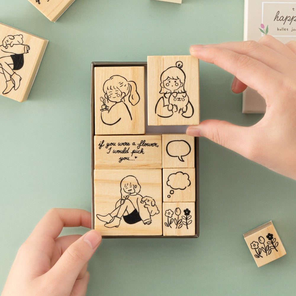 Hand taking out girl with dog stamp from Tsuki Happy Day bullet journal stamp set box