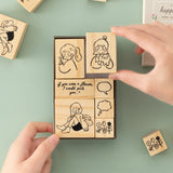Hand taking out girl with dog stamp from Tsuki Happy Day bullet journal stamp set box
