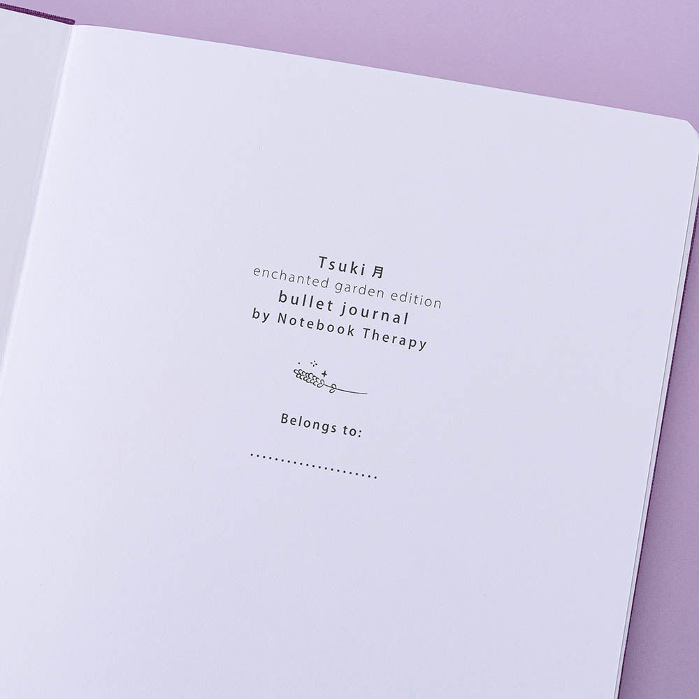 Tsuki ‘Enchanted Garden’ lavender foil design on purple linen bullet journal on purple background
