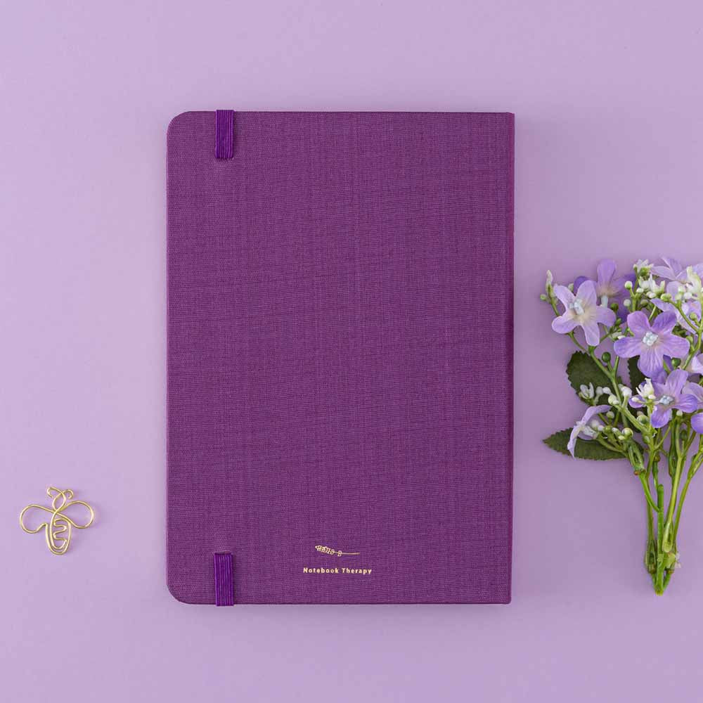 Tsuki ‘Enchanted Garden’ back cover on purple linen bullet journal on purple background