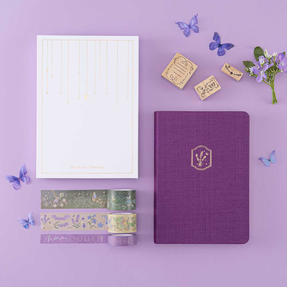 Tsuki ‘Enchanted Garden’ lavender foil design on purple linen bullet journal on purple background 