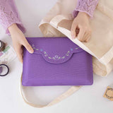 Hand putting the notebook pouch in a canvas tote bag