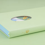Angled photo of Tsuki Four Seasons Summer Collectors Edition 2022 sage bullet journal notebook showing the gold foil sunflower details on the spine