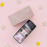 Tsuki Constellations Washi Tape Set by Notebook Therapy on pink background with star-shaped decorations around the open box