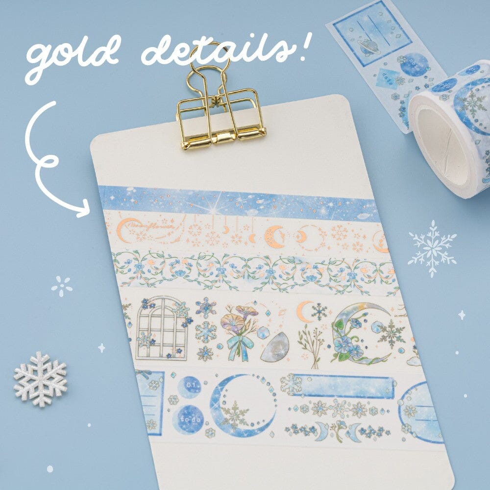 Hands holding 5x washi rolls with snowy winter design