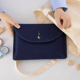 Hands putting Cloud Dreamland notebook pouch in a tote bag