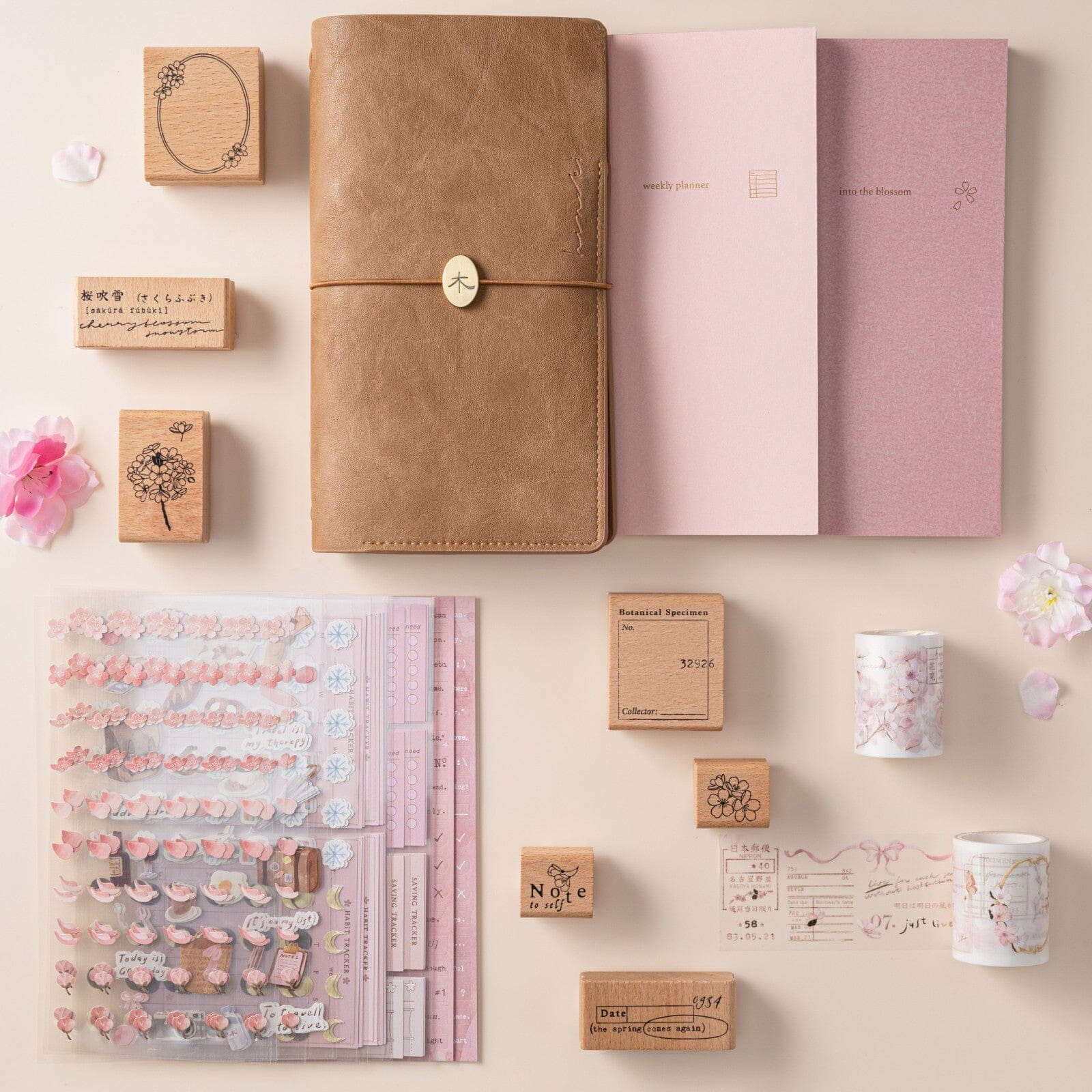 Flatlay of Hinoki travel notebook with hinoki into the blossom mixed insert + sticker set, washi tapes and stamps
