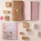 Flatlay of Hinoki travel notebook with hinoki into the blossom mixed insert + sticker set, washi tapes and stamps
