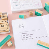 Close up of Tsuki ‘Flutter + Dream’ Bullet Journal Stamp Set by Notebook Therapy x Pelinkan open Tsuki Cloud White ‘Flutter + Dream’ Limited Edition Bullet Journal by Notebook Therapy x Pelinkan on pastel pink background