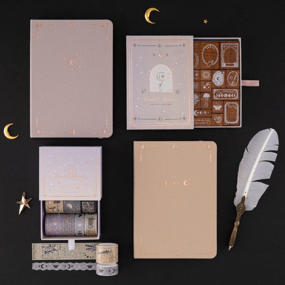Flatlay of Tsuki ‘Moonlit Alchemy’ collection including Tsuki ‘Moonlit Alchemy’ stamps , Stardust Dawn bullet journal, Moonlit Dusk bullet journal and Moonlit Alchemy washi tapes