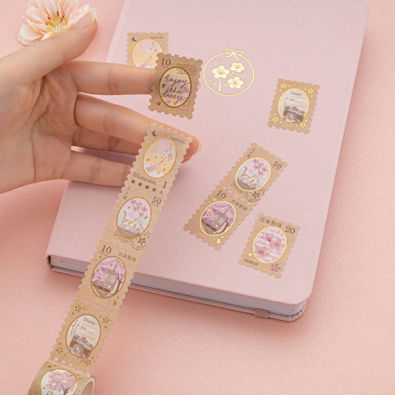 Hand holding stamp washi tape showing cherry blossom designs