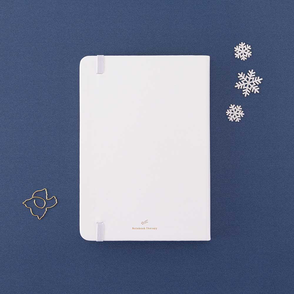 Back cover of Tsuki ‘Winter Journey’ Limited Edition Bullet Journal with free paperclip gift on navy background