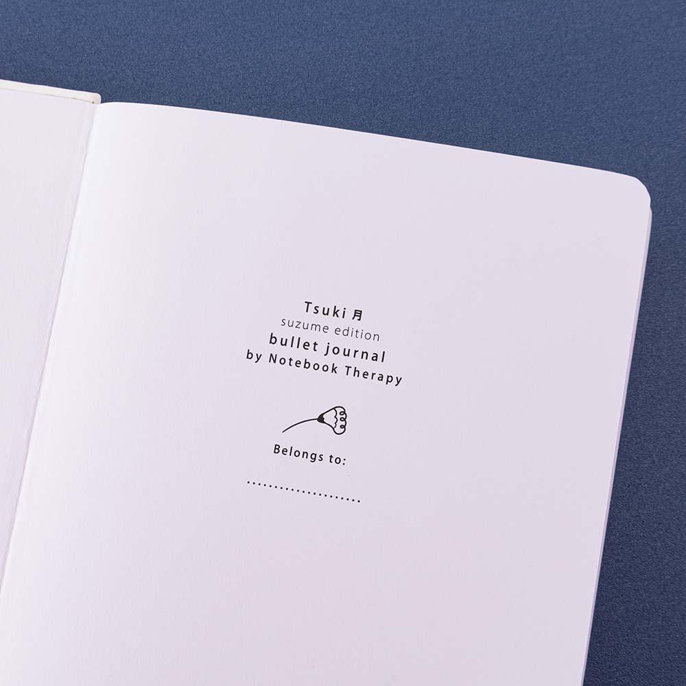 Close up of the open front page of Tsuki ‘Suzume’ Winter Limited Edition Bullet Journal on navy background