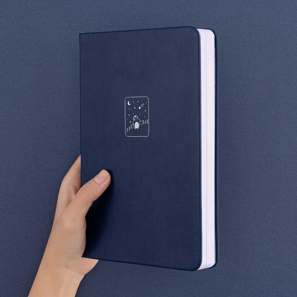 Tsuki ‘Winter Wishes’ Limited Edition Bullet Journal held in hand in navy background