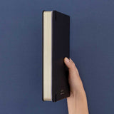 Tsuki ‘Winter Journey’ Limited Edition Bullet Journal held in hand at spine angle in navy background