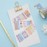 Close up of Tsuki ‘Four Seasons’ Washi Tapes by Notebook Therapy x Milkkoyo on white card clipboard with gold pen and white flower on light blue background