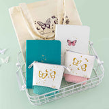 Tsuki Teal Sky ‘Flutter + Dream’ Limited Edition Bullet Journal by Notebook Therapy x Pelinkan and Tsuki Cloud White ‘Flutter + Dream’ Limited Edition Bullet Journal by Notebook Therapy x Pelinkan and Tsuki ‘Flutter + Dream’ Pop-Up Pencil cases in teal and pastel pink by Notebook Therapy x Pelinkan and Tsuki ‘Flutter + Dream’ Tote Bag by Notebook Therapy x Pelinkan in white basket with butterflies in mint background