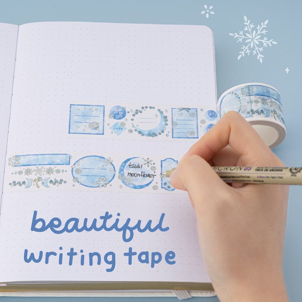 Hand holding a Micron pen and writing Tsuki Moonflower on 30mm writing washi tape with text “beautiful writing tape”