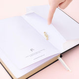 Close up of Tsuki Lunar Notes bullet journal back pocket and free gift image on pink background