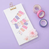 Tsuki Floral washi tapes laid out with mini banners made with washi tape on card, on lilac background