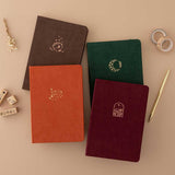 Tsuki ‘Kitsune’ Limited Edition Fox Bullet Journal and Tsuki ‘Nara’ Limited Edition Bullet Journal and Tsuki ‘Kinoko’ Limited Edition Bullet Journal and Tsuki ‘Midnight Garden’ Limited Edition Bullet Journal with Tsuki ‘Maple Dreams’ Washi Tapes and Tsuki ‘Maple Dreams’ Bullet Journal Stamps with gold pen and dried flowers on beige background