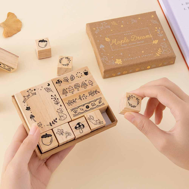 Tsuki ‘Maple Dreams’ Bullet Journal Stamp Set held in hands with autumn leaves in cream background