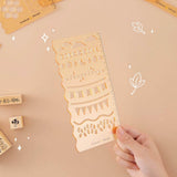 Tsuki Bullet Journal Stencil Set in neutral held in hand at an angle withTsuki ‘Maple Dreams’ Bullet Journal Stamps in beige background