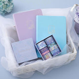 Tsuki Endless Summer Limited Edition Bullet Journals in Lilac Bloom and Petal Blue with Tsuki Endless Summer Washi Tape Set in basket with netting on light blue background