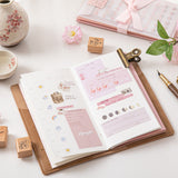 Hand holding grid paper refill from Hinoki travel notebook