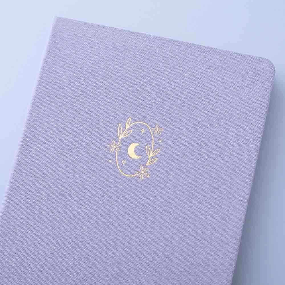 Close up of the front cover of Tsuki ‘Full Bloom’ Limited Edition Bullet Journal on lilac background
