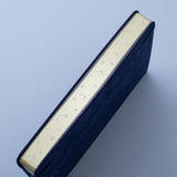 Tsuki deep blue textured vegan leather Gentle Giant luxury edition notebook at an angle with gold page edges on blue background
