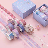 Close up of Tsuki ‘Sakura Journey’ Washi Tape Set rolled out with cherry blossoms on light pink background