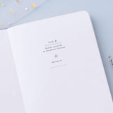 Close up of open front page of Tsuki ‘Full Bloom’ Limited Edition Bullet Journal on lilac background