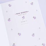 Close up of open front page of Tsuki Four Seasons: Summer Edition Bullet Journal designed with @milkkoyo on lilac background