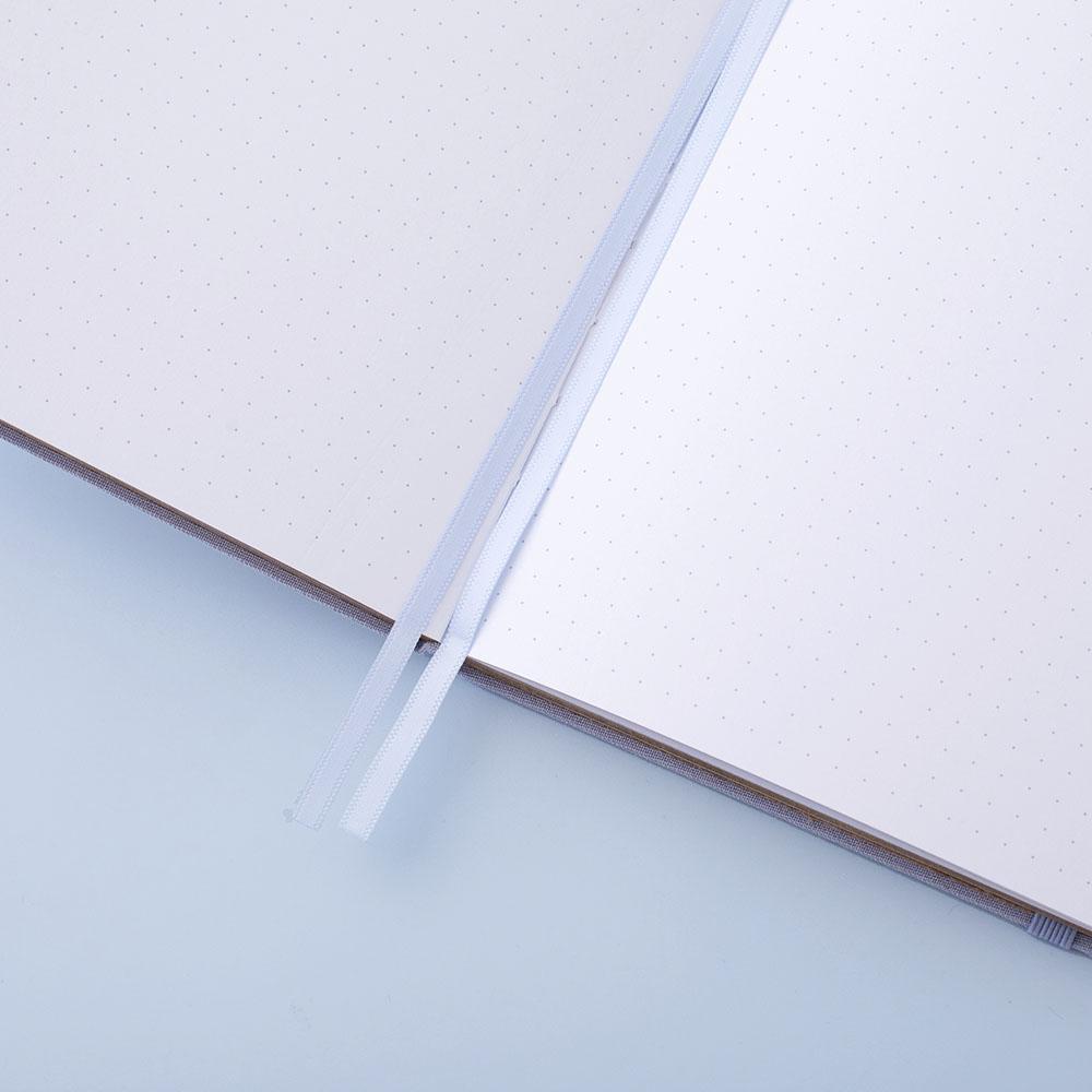 Close up of open page spread of Tsuki ‘Full Bloom’ Limited Edition Bullet Journal with two bookmark ribbons on lilac background