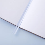 Close up of open page spread of Tsuki ‘Full Bloom’ Limited Edition Bullet Journal with two bookmark ribbons on lilac background