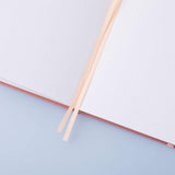 Close up of open page spread of Tsuki ‘Suzume’ Limited Edition Bullet Journal with two bookmark ribbons on lilac background