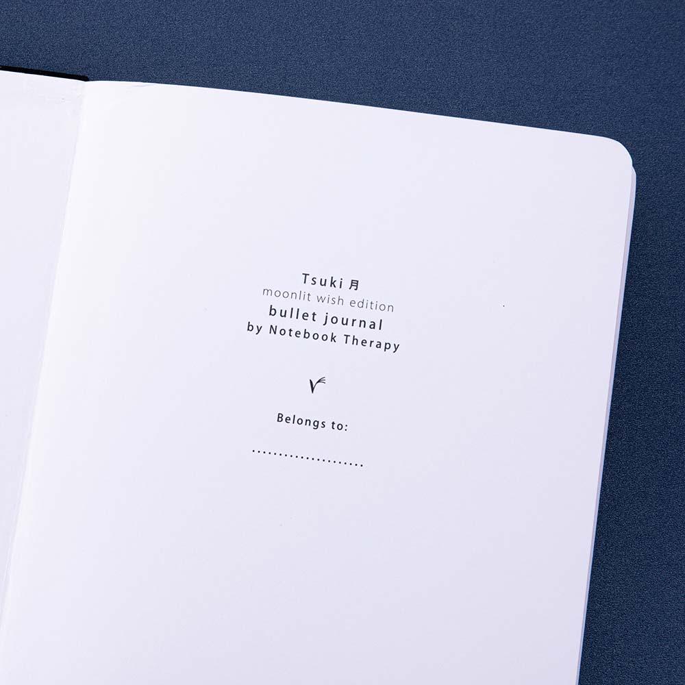 Close up of the open front page of Tsuki ‘Moonlit Wish’ Limited Edition Bullet Journal on dark blue background