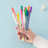 Gelly Roll Pens held in hand with Tsuki Washi Tape in light teal background