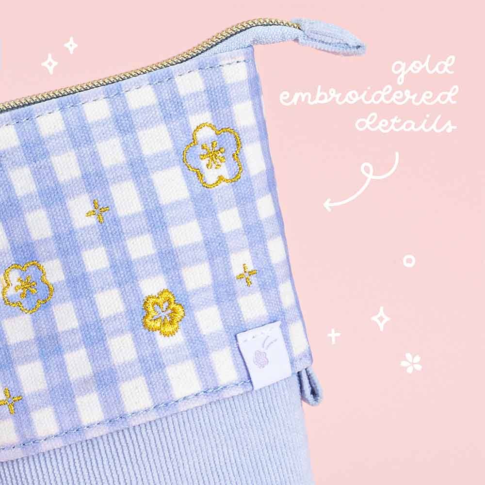 Close up of gold embroidered details of Tsuki ‘Sakura Journey’ Pop-Up Pencil Case on light pink background 
