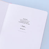 Close up of open front page of Tsuki ‘Lunar Blossom’ Limited Edition Bullet Journal on light blue background