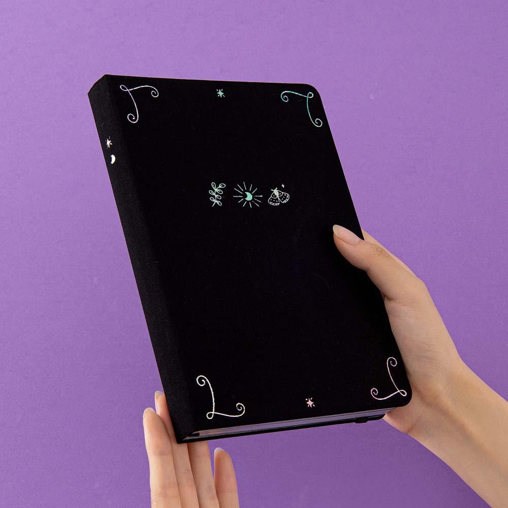 Tsuki ‘Moonlit Spell’ Limited Edition Holographic Bullet Journal held in hands in purple background