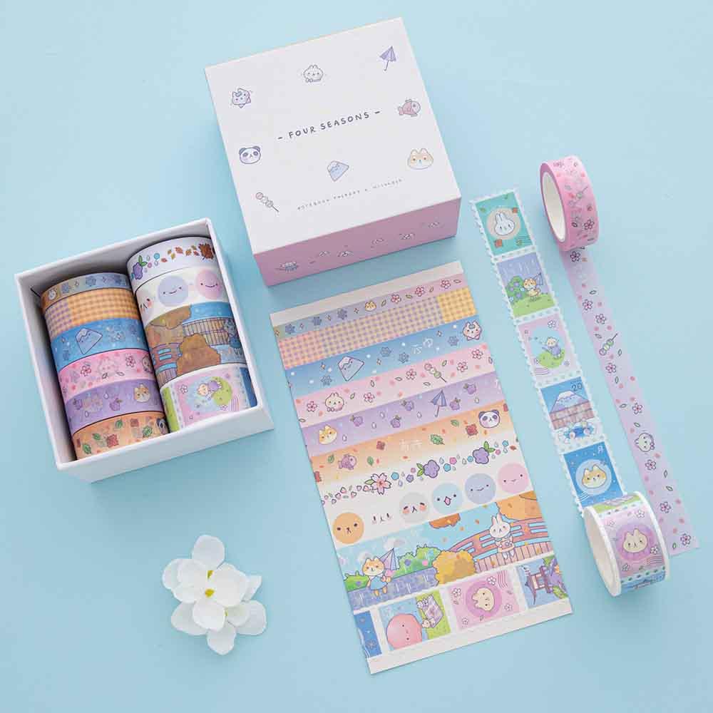 Tsuki ‘Four Seasons’ Washi Tape Set by Notebook Therapy x Milkkoyo shown on white card with white flower on light blue background