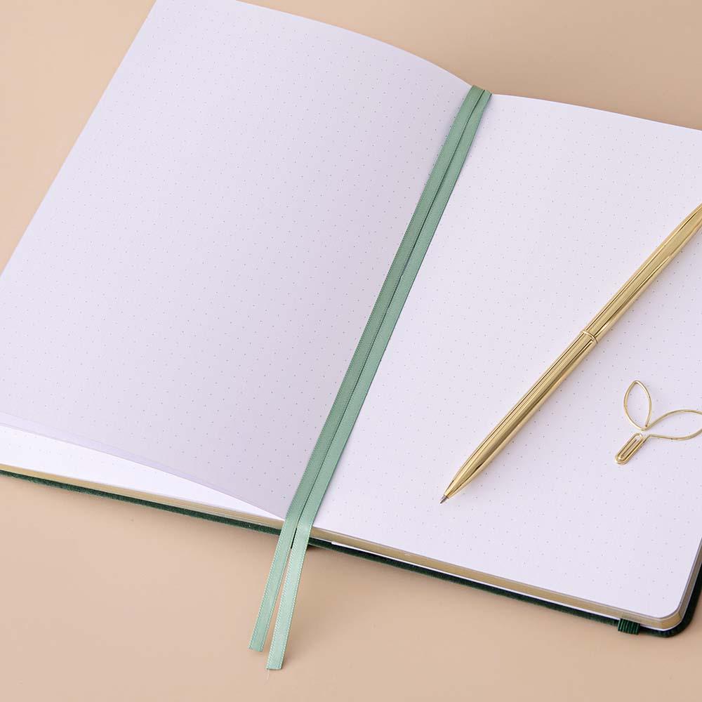 Close up of open page spread of Tsuki ‘Midnight Garden’ Limited Edition Bullet Journal with two bookmark ribbons on beige background